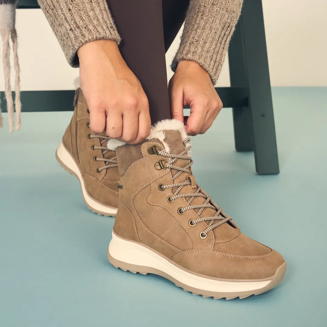 Close-up of a woman lacing Yellow suede winter boots